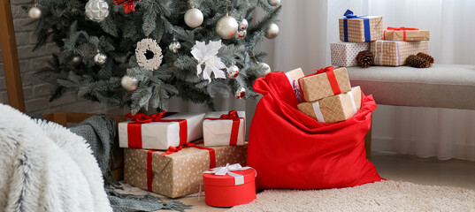 Santa bag with gifts and Christmas tree in living room