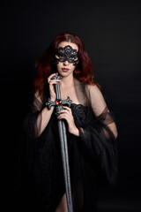 close up portrait of beautiful female model wearing black dress and dark veil like a widows shroud.  isolated on studio background with moody lighting.