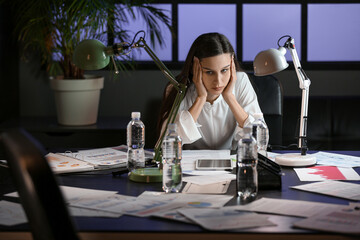 Tired businesswoman sitting in office at night