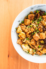 healthy plant-based food, vegan noodles stir fry with broccoli peas and marinated tofu chunks