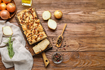 Composition with board of tasty Italian focaccia, peppercorns and onion on wooden background
