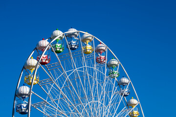 Closeup of A Colorful Ferris Wheel Over Blue Sky.