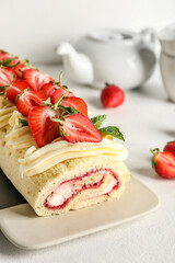 Plate with tasty strawberry roll cake on light background, closeup