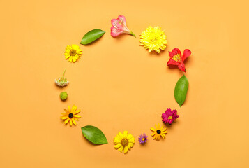 Frame made of flowers and leaves on color background