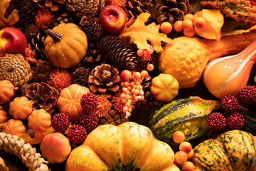 Autumn composition on a rustic wooden background. Decorative pumpkins, various leaves, pine cones,...