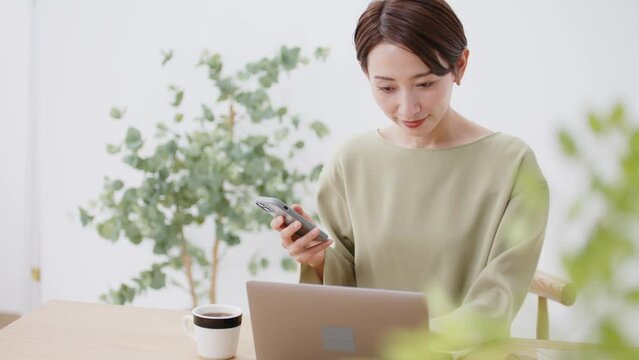 女性・ノートパソコン・スマートフォン