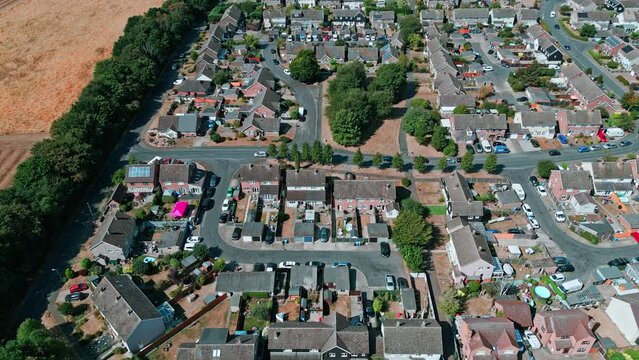 Aerial footage of the small Suffolk village of Acton surrounded by farmland and golden fields.