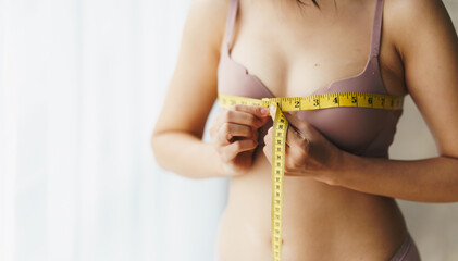 Women's breast measure concept. A woman wearing a bra to measure her chest circumference.