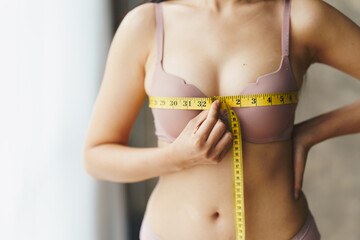 Women's breast measure concept. A woman wearing a bra to measure her chest circumference.