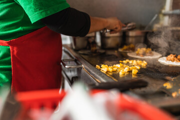 Chef cooking ingredients for tacos in a restaurant kitchen
