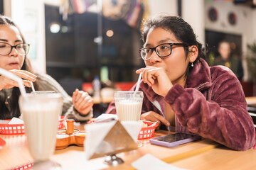 Woman drinking a milk shake in a mexican restaurant