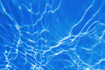 Defocus blurred transparent blue colored clear calm water surface texture with splashes and bubbles. Trendy abstract nature background. Water waves in sunlight with copy space. Blue watercolor shining