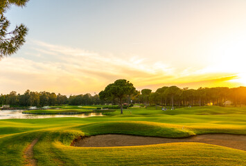 Panorama of the most beautiful sunset or sunrise. Sand bunker on a golf course without people with...