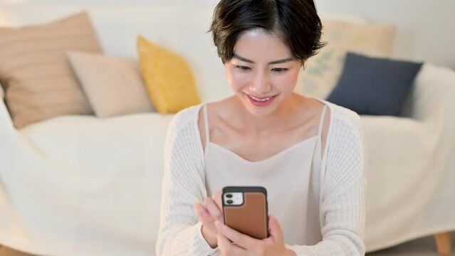 寝る前にスマホをみる女性