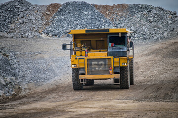 Work of trucks and the excavator in an open pit on gold mining