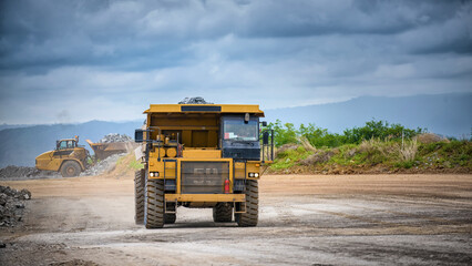 Work of trucks and the excavator in an open pit on gold mining