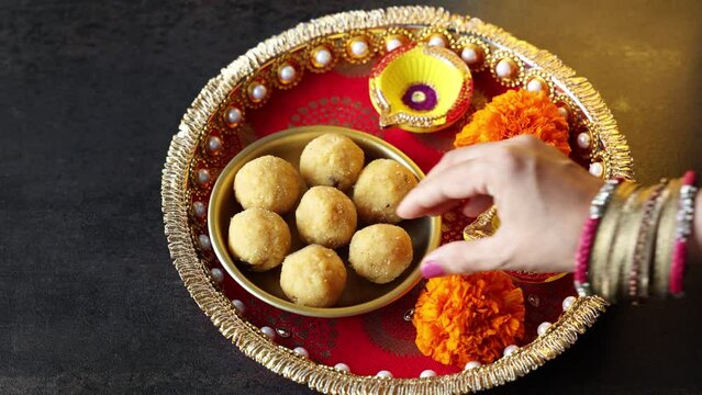 Women taking Diwali sweets Laddu or ladoo Jalebi peda Indian sweet festival dish mithai Dussehra Holi ganesh chaturthi Ram navami Durga pooja ashtami Navratri Mumbai Kerala India Sri Lanka