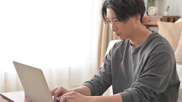 リビングでパソコンをする男性