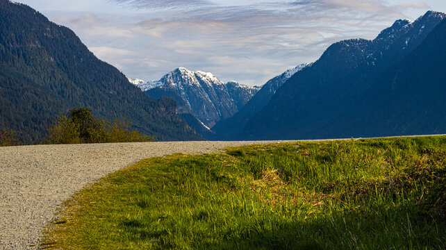 A gravel road leads off into the distance toward a mountain range.