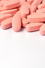 Pink calcium tablets on a white background. Copy space.