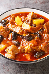 Lamb, prune and potatoes ragout closeup in the bowl on the table. Vertical