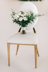 Wedding bouquet of the bride on a white chair