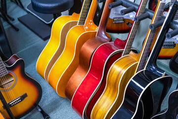 Wooden classical guitars in selective focus with fade effect. Sale of stringed instruments in a...