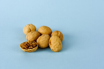 Walnut whole and open on a blue background. The concept is a healthy snack.