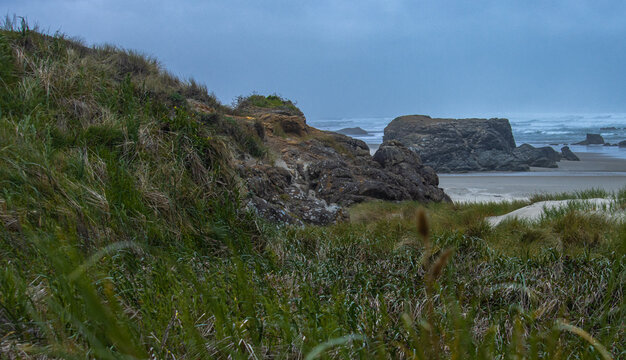 Rocky landscape in front of the beach with waves rolling in the background