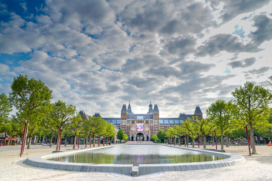 Rijksmuseum with pond and trees under a moody sky, Amsterdam, The Netherlands