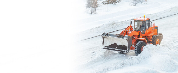 A large orange tractor removes snow from the road and clears the sidewalk. Cleaning and clearing...