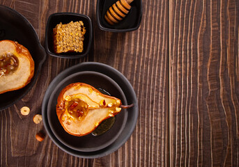 Honey or maple syrup roast pears with walnuts. Vegetarian diet health delicious dessert.