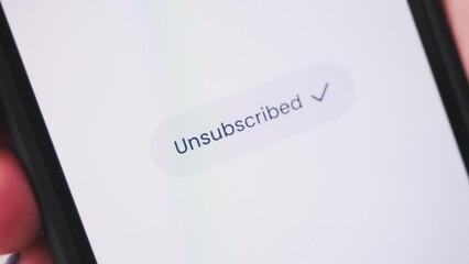 Young lady pressing unsubscribe button on smartphone. Social media concept.