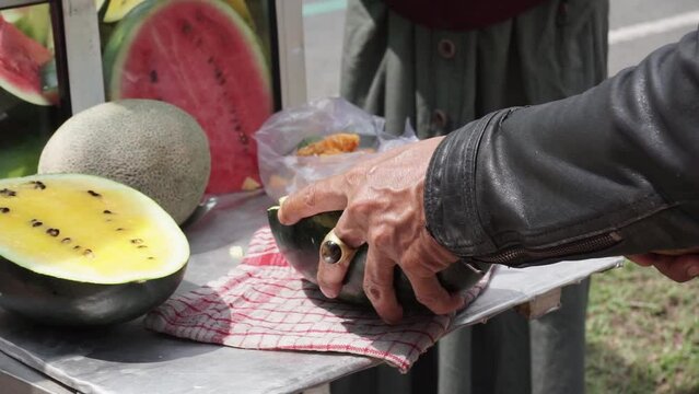 The process of serving rujak(fruit salad) by the seller to the buyer. Rujak is a typical Indonesian food.