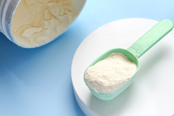 Collagen peptides powder and jar on blue background. Beauty daily concept.