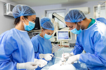 Group of surgeons doing surgery in hospital operating theater. Medical team doing critical...