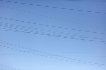 Electric wires against the blue sky. Background