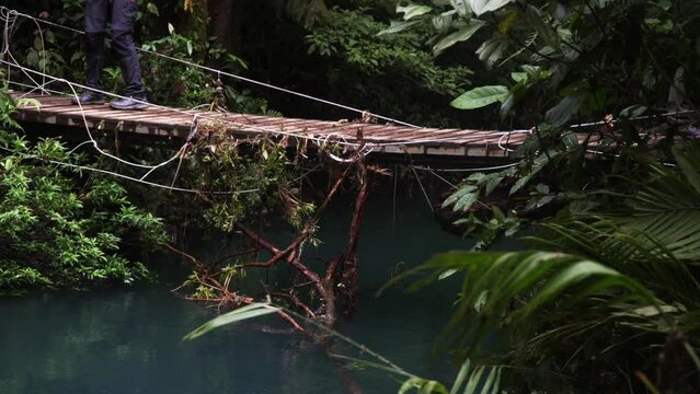 Lower torso of people crossing a rope suspension bridge at rainforest rio celeste costa rica