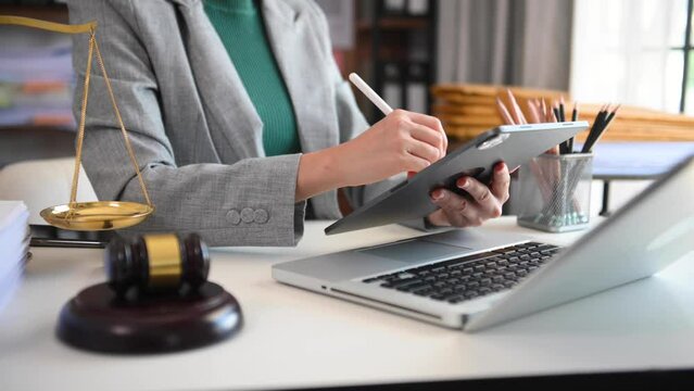 justice and law concept.Male judge in a courtroom  the gavel, working with smart phone and laptop and digital tablet computer on black table in morning light .