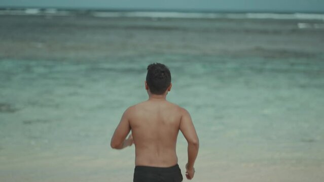 Topless Fit Asian Indonesian Man Running to The Beach