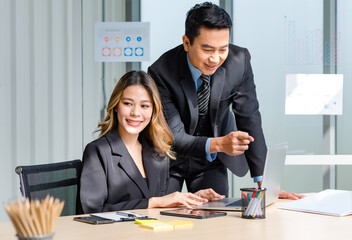 Millennial Asian cheerful successful professional male businessman manager in formal suit and female businesswoman secretary posing smiling holding fists up together in company office meeting room
