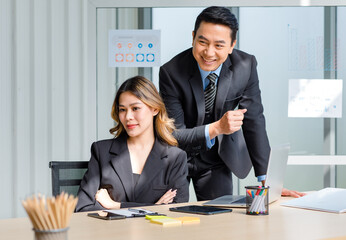 Millennial Asian cheerful successful professional male businessman manager in formal suit and female businesswoman secretary posing smiling holding fists up together in company office meeting room