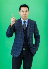 Millennial Asian smart handsome cheerful proud successful professional male businessman ceo entrepreneur in plaid formal suit and necktie standing smiling posing on green background.