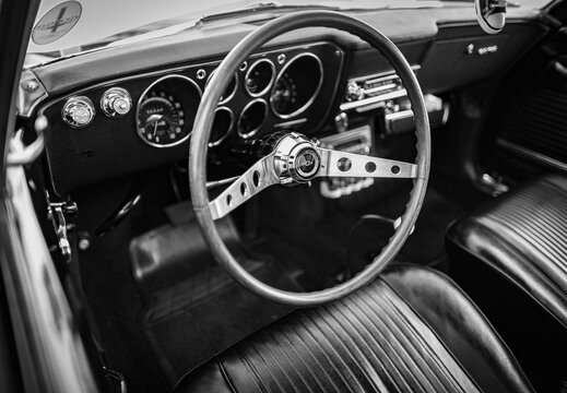 Old vintage car steering wheel and cockpit. Retro styled image of an old car radio inside classic car Chevrolet