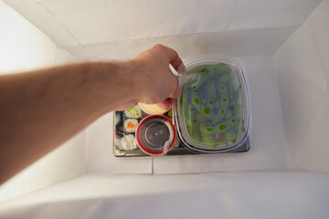 Growing person picking berries from paper bag