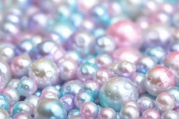Beautiful background with pearl pearls, top view. Abstract texture for festive backgrounds. Shiny surface of Christmas decorations. Gems close-up. Multicolored bright background.