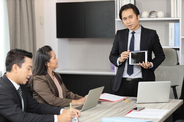 Collaborative process of professional businesspeople going over on new project together, using tablet presentation and brainstorming ideas, coworker and working together at office meeting concept