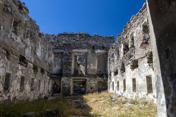 Fototapeta na wymiar Ruins of Fort Malamot at Lake Montcenis (Moncenisio) on the border between Italy and France. Old ancient historical fort ruins in stone in the Alps mountains 