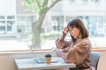 腕時計を見ながら困る忙しい日本人ビジネスウーマン
