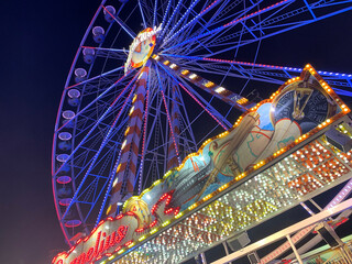 ferris wheel at a fair near nach. colorful lighting